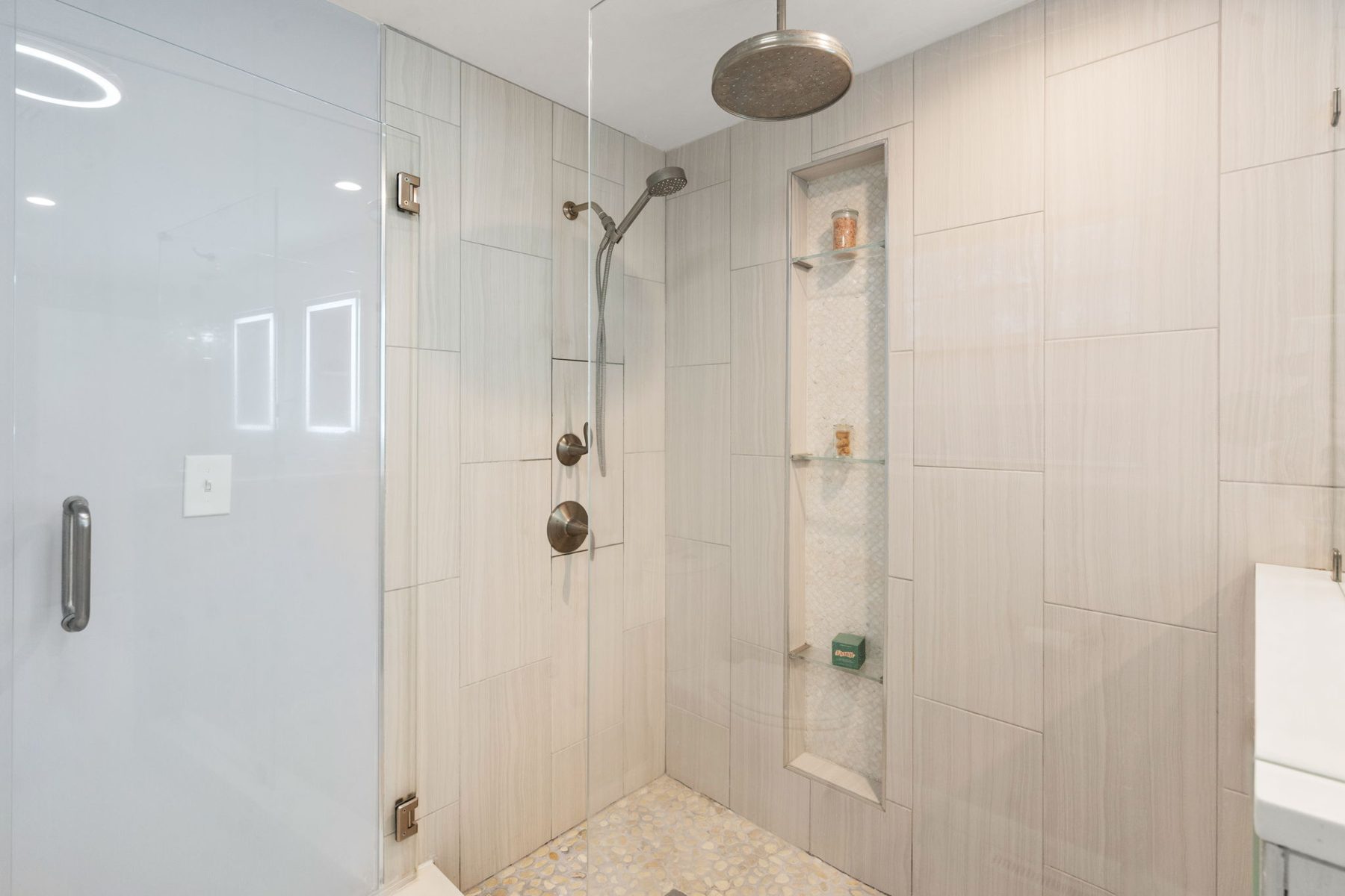 Condor shower — rain head, pebble floor, tiled niche — after