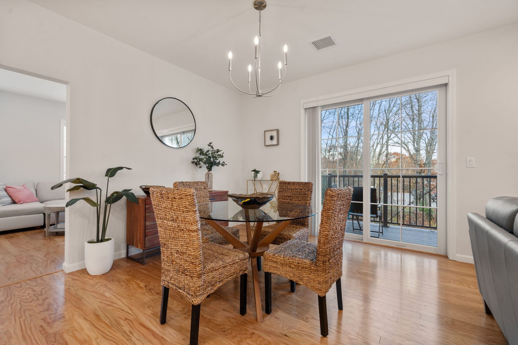 Copperworks dining — round glass table, seagrass chairs, view to the deck — after