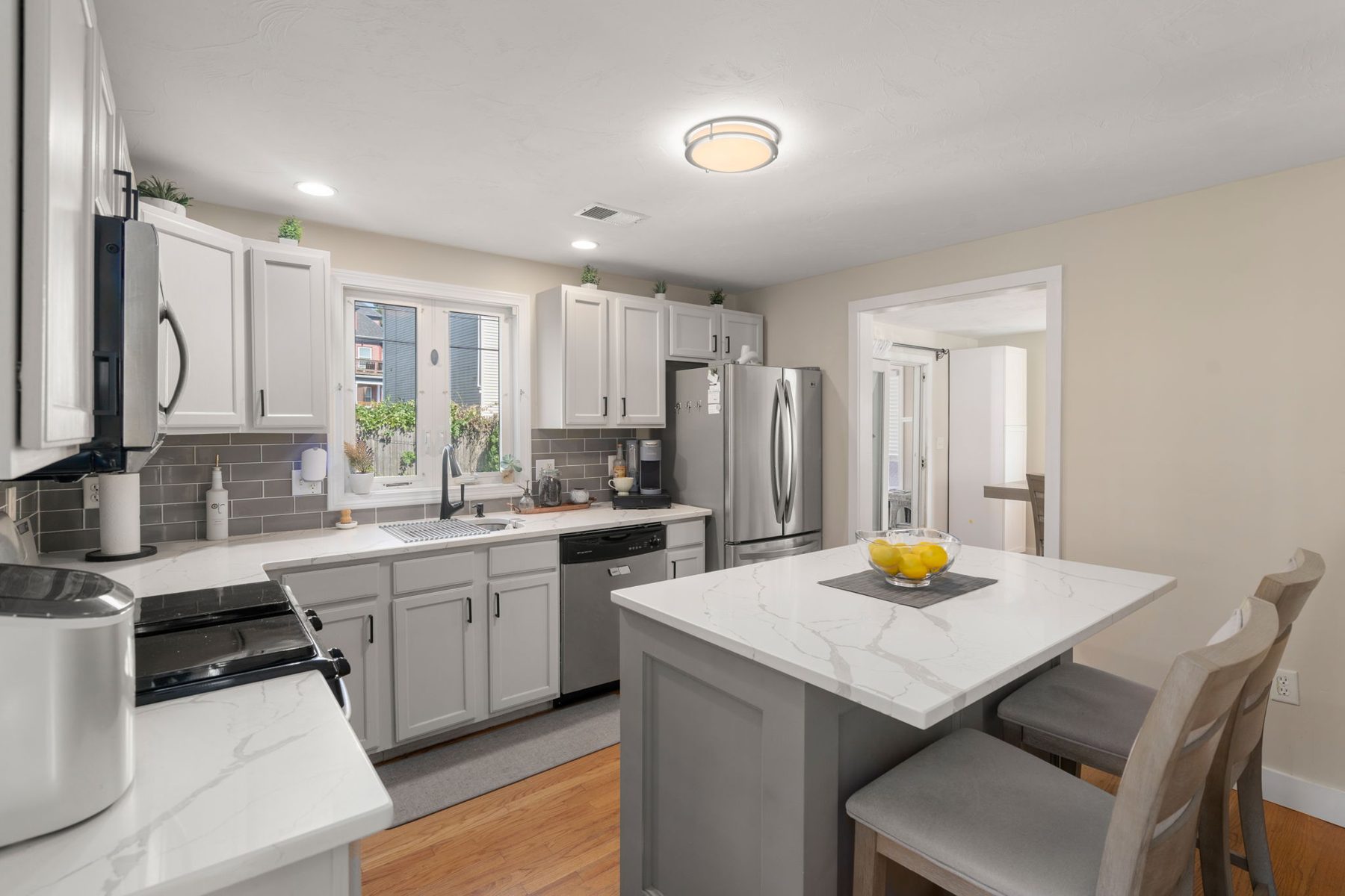 Norwell kitchen — quartz island, grey subway, lemons — after