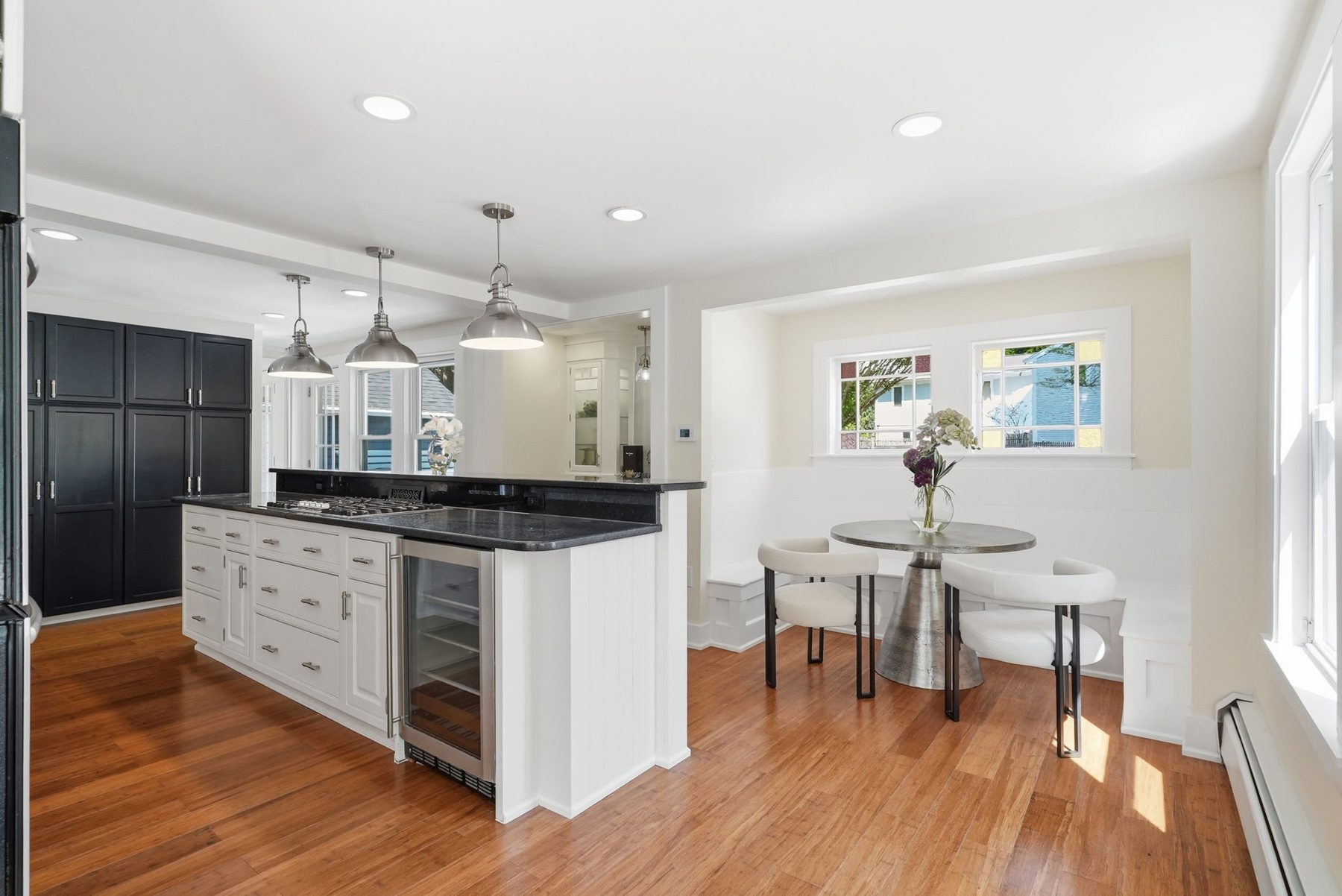 Pemberton kitchen — black pantry wall, white island with wine fridge, banquette — after