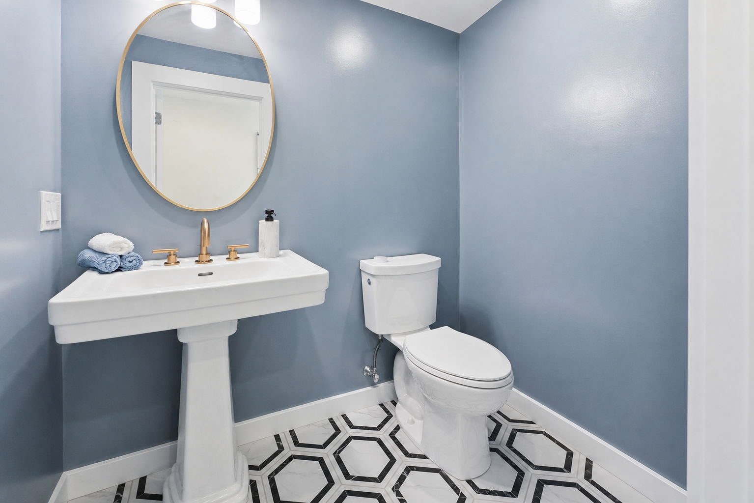 Pemberton powder — navy walls, hex tile, pedestal sink — after