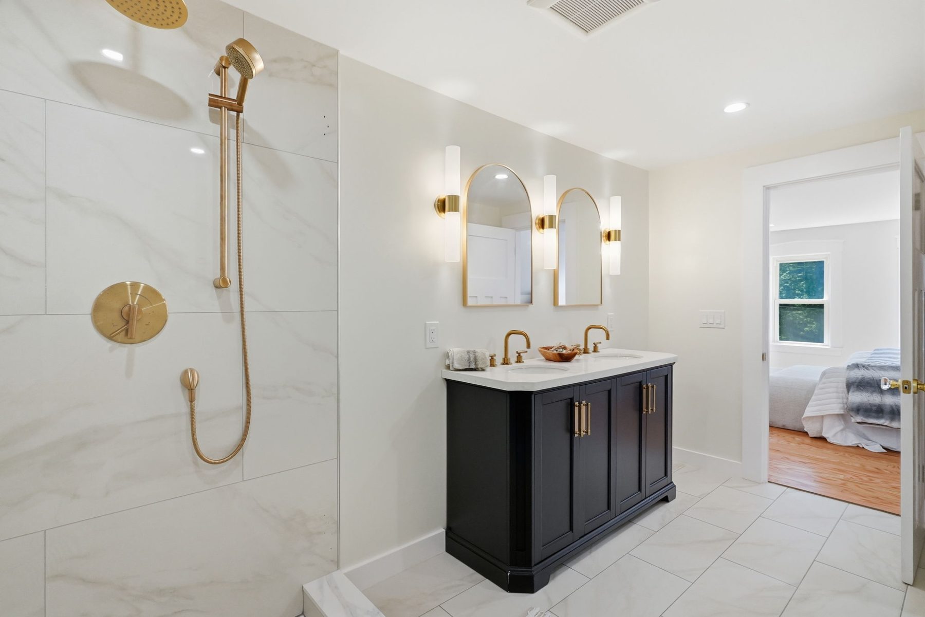 Pemberton primary bath — black vanity, brass, marble walk-in shower — after