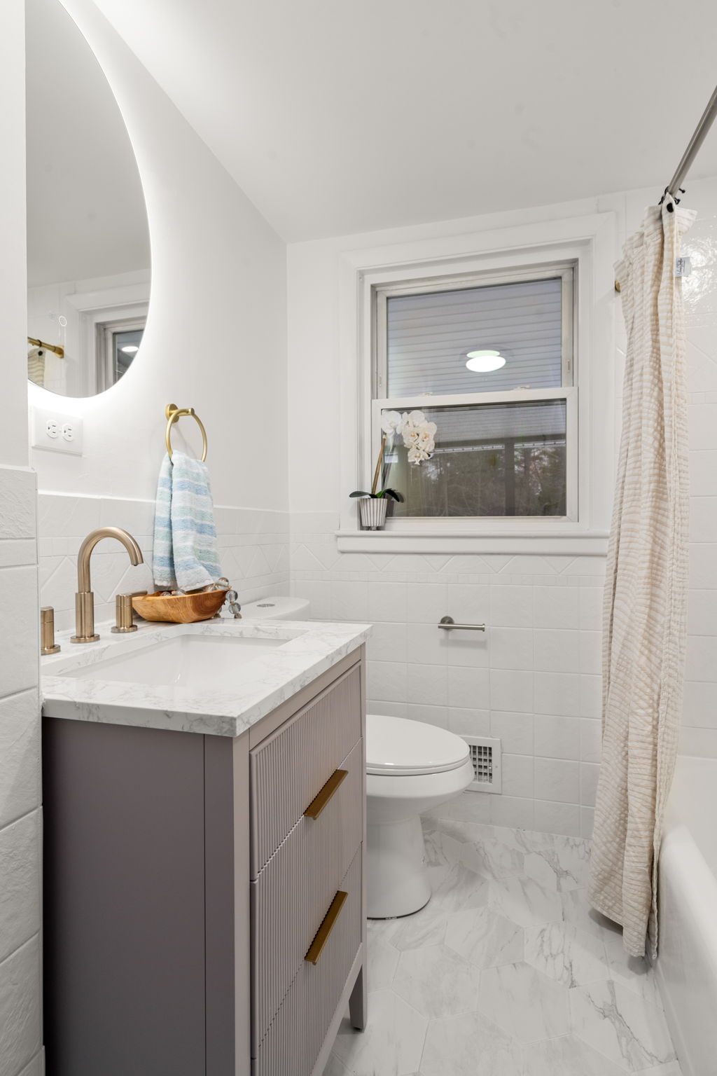 Wilshire bath — hex marble floor, taupe vanity, backlit mirror — after