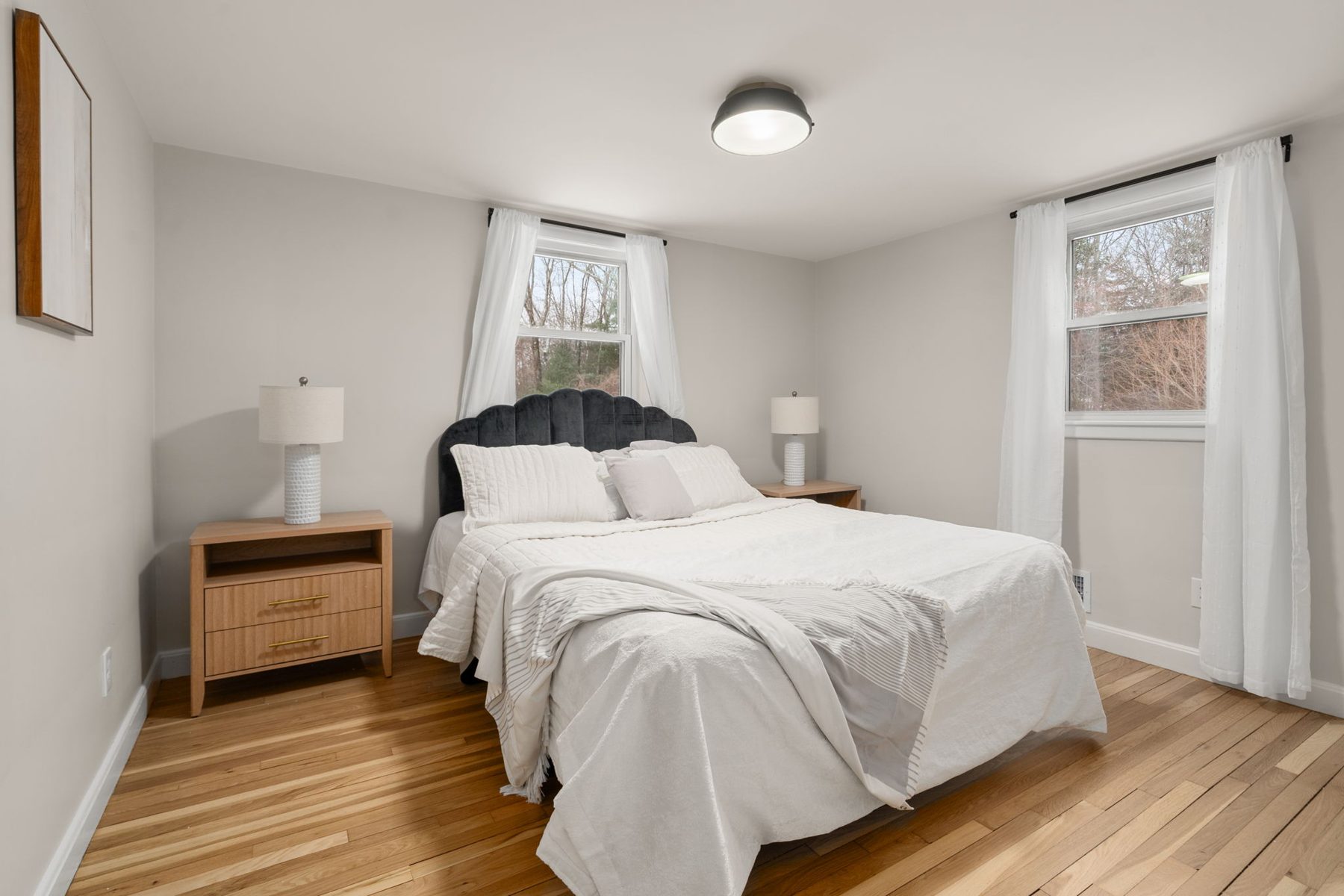 Wilshire bedroom — black velvet headboard, refinished floors — after